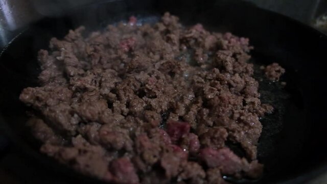Frying minced meat in a pan with onions and garlic.