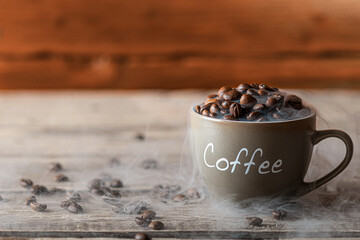 Coffee beans in a coffee cup on a wooden table. Rural background. Place for the inscription