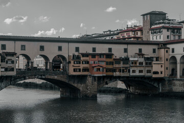 Naklejka premium View of medieval stone bridge Ponte Vecchio and the Arno River from the Ponte Santa Trinita (Holy Trinity Bridge) in Florence, Tuscany, Italy. Florence is a popular tourist destination of Europe