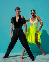 Latin Dance Couple Posing in Front of a Blue Background