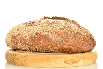 One loaf of freshly baked buckwheat bread on a round wooden tray, close-up, isolated on white.