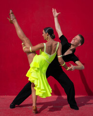 Latin Dance Couple Posing in Front of a Red Background