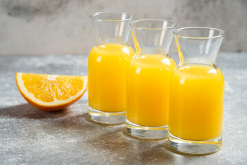 Glass jars of orange juice and slice of orange
