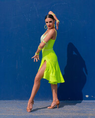 Latin dancer in front of a dark blue wall