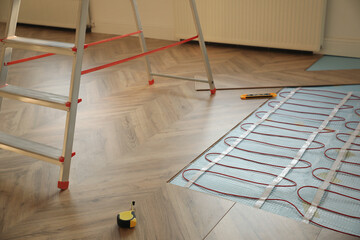 Obraz premium Installation of electric underfloor heating system indoors