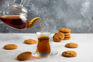 A glass cup of tea with delicious cookies
