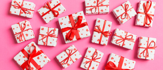 Fototapeta na wymiar Top view of white gift boxes with hearts on colorful background. Valentine's Day concept