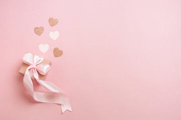 Gift boxes with pink ribbon and hearts on pastel pink background. Valentines day composition with free space. Top view, flat lay.