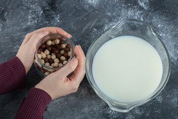 Female hands holding glass jar of cereal balls