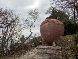 Obraz premium Big ceramic pot in the autumn botanical garden. Plants with autumn leaves around.