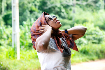 beautiful young woman with a scarf and sunglasses in the countryside, smiling.