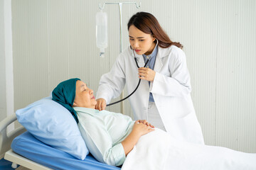 Asian medical doctor with stethoscope diagnosis old senior cancer illness patient on hospital bed