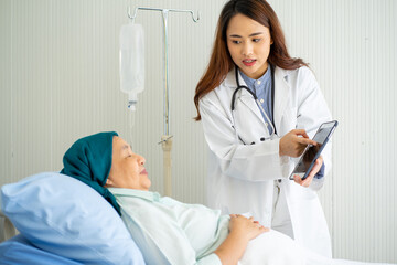 Asian medical doctor with stethoscope diagnosis old senior cancer patient on hospital bed