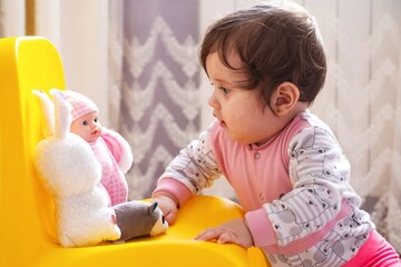 10 months old baby girl playing with toys. Portrait of a cute little girl