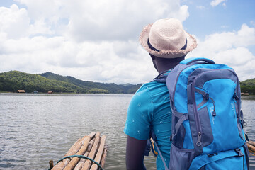 African traveler man rafting in river with backpack