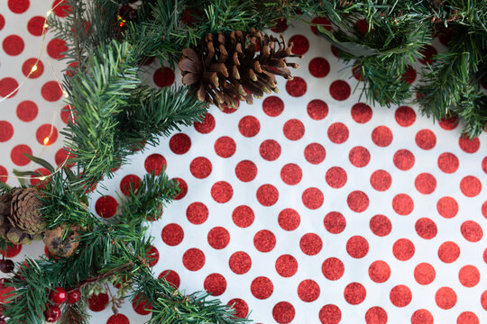 christmas scene on red and white polka dot wrapping paper with golden ornaments, wreath, and golden bells