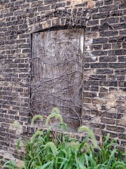 Old Boarded Up Window in Abandoned Brick Building