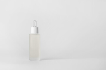 Face serum bottle on light background..