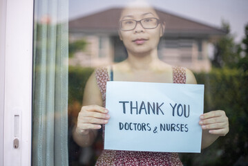 Women showing Thank you Doctors and Nurses sign at home for encouraging Doctors and Nurses in covid-19 coronavirus situation