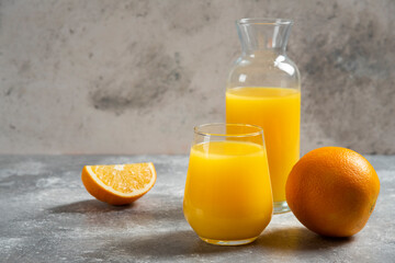 Naklejka na ściany i meble A glass cups of orange juice and slices of orange