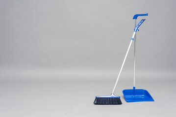 Dust pan and brush on the gray background with copy space.