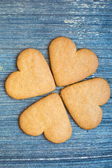 Four ginger bread biscuit on aged grey wooden surface. Postcard for saint valentines day background. Four-leaf clover symbol of luck. Pastry for sweetheart. February holidays.