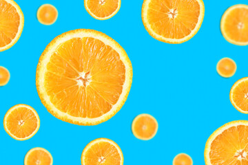 Orange round slices in flight on a turquoise background with space for text. Template, layout of your advertisement.