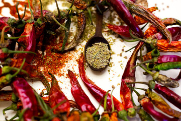 Naklejka premium Hot red peppers next to dry spices. White background.