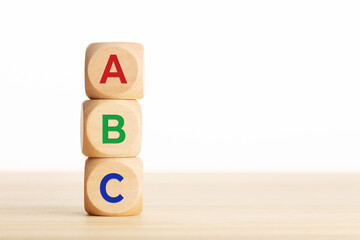 ABC letters alphabet on wooden blocks stacked on wood table. Copy space