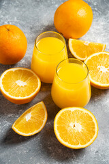 A glass cups of orange juice and slices of orange