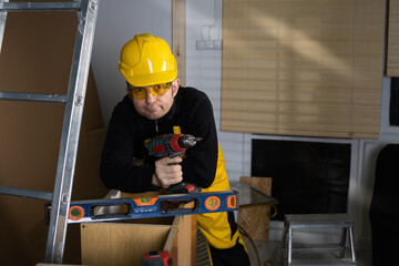 A general construction worker with a cordless screwdriver in hand is ready to start work....