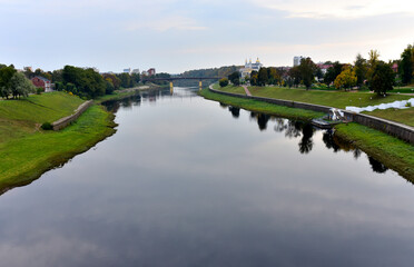 Fototapeta na wymiar View of the Western Dvina (Zapadnaya Dvina) river in the center of the city of Vitebsk in the Republic of Belarus. Autumn landscape in town