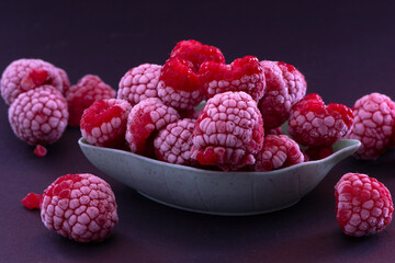 Frozen Raspberries in a Bowl placed on a black background