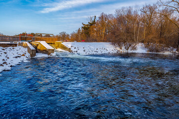 Amery Dam on the Apple River in Amery Wisconsin during winter with snow. 
