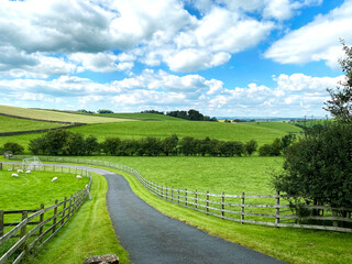 Fototapeta na wymiar Narrow lane leading from, Yarlside Lane, with fields and hills in the distance in, Horton, Gisburn, UK