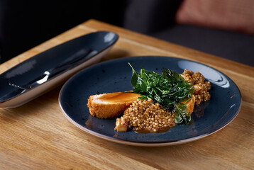 Chicken fillet with green buckwheat and porcini mushrooms on the table, in a restaurant, menu food concept.