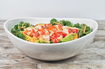 Lobster salad with avocado, tomato, lettuce on a wooden table