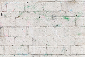 White brick wall with soft paint spots, close-up