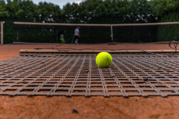 sweeping orange clay on an outdoor tennis court.