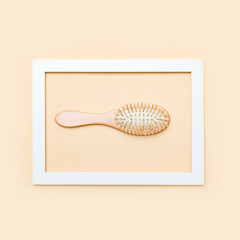 Hair brush in the frame on a beige background. Eco lifestyle concept...