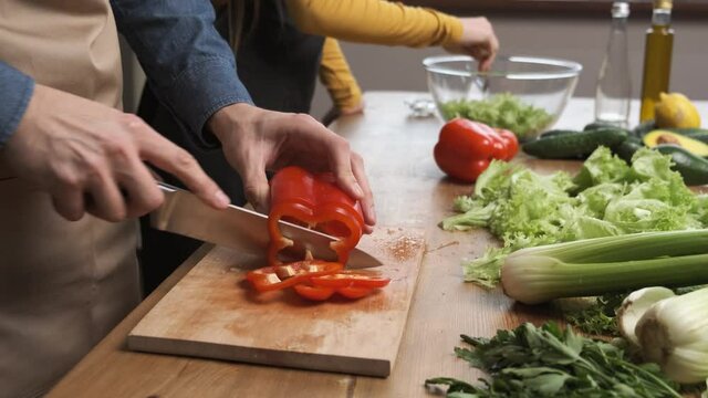 Cooking salad at home: man hands slicing red papper for a salad. Side view. Healthy dinner meal concept 4k