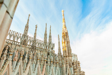 Roof of Milan Cathedral Duomo di Milano with Gothic spires and white marble statues. Top tourist...