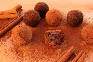 Chocolate truffles, cocoa powder and cinnamon sticks on a craft paper background. View from overhead 