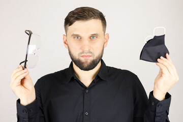 the man is holding medical glasses and a protective mask on a white background