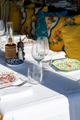Before lunch time, empty cafes with served tables and tablecloths waiting for guests in Saint-Tropez, Provence, France