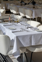 Before lunch time, empty cafes with served tables and tablecloths waiting for guests in Saint-Tropez, Provence, France