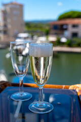 Summer party with sparkling champagne wine and sail boats haven of Port Grimaud on background, Provence, France