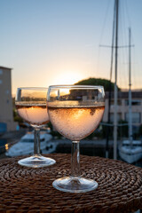 Drinking of local rose wine at sunset with sail boats haven of Port Grimaud on background, Provence, France
