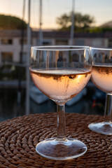 Drinking of local rose wine at sunset with sail boats haven of Port Grimaud on background, Provence, France
