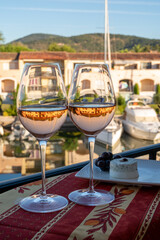 Tasting of local rose wine and soft french goat cheese in summer with sail boats haven of Port Grimaud on background, Provence, France